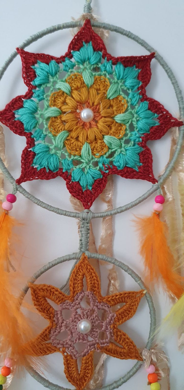 Decorative dreamcatcher with colorful crochet patterns and with feathers