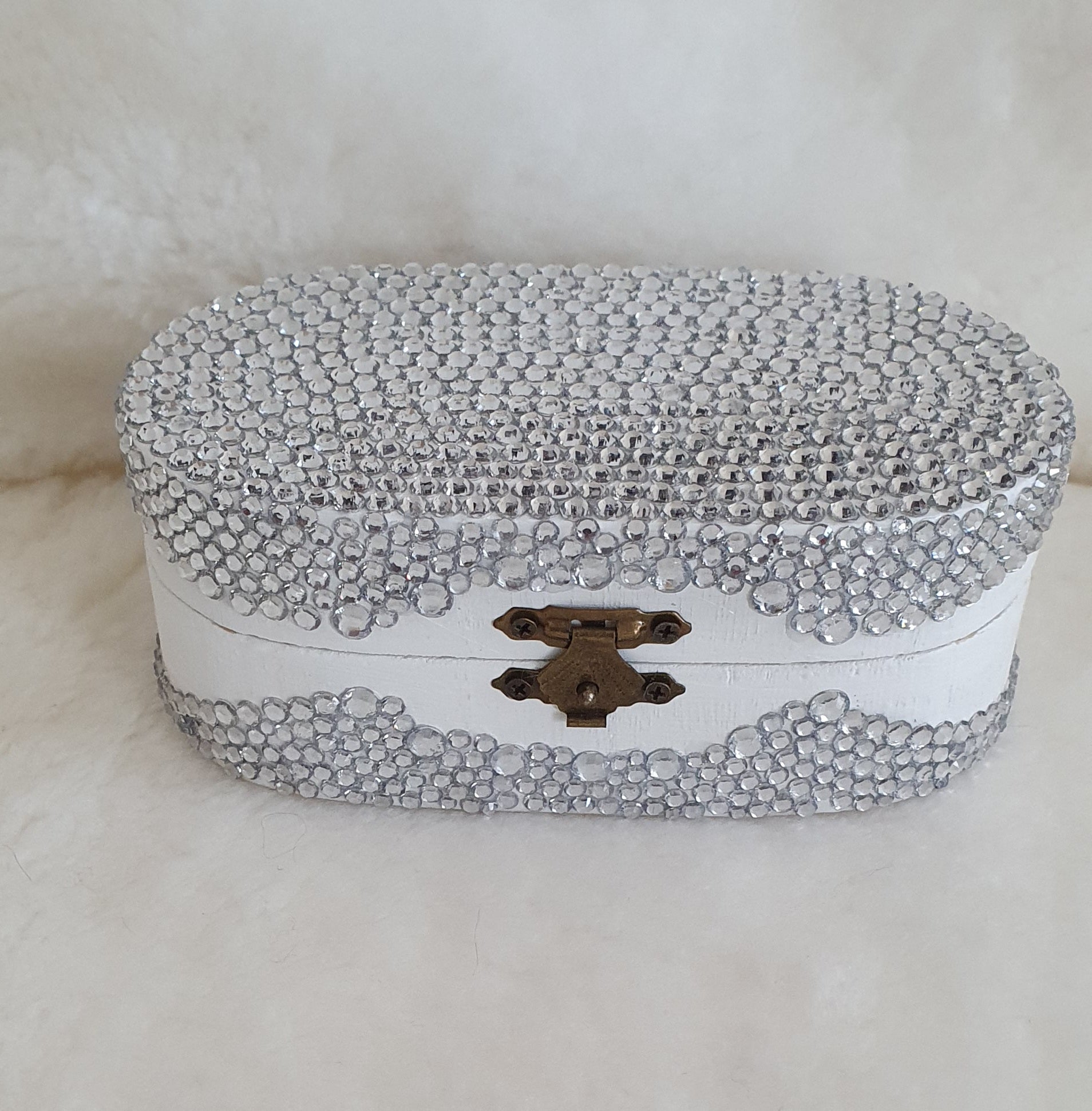Decorative small box with crystal embellishments on a white background