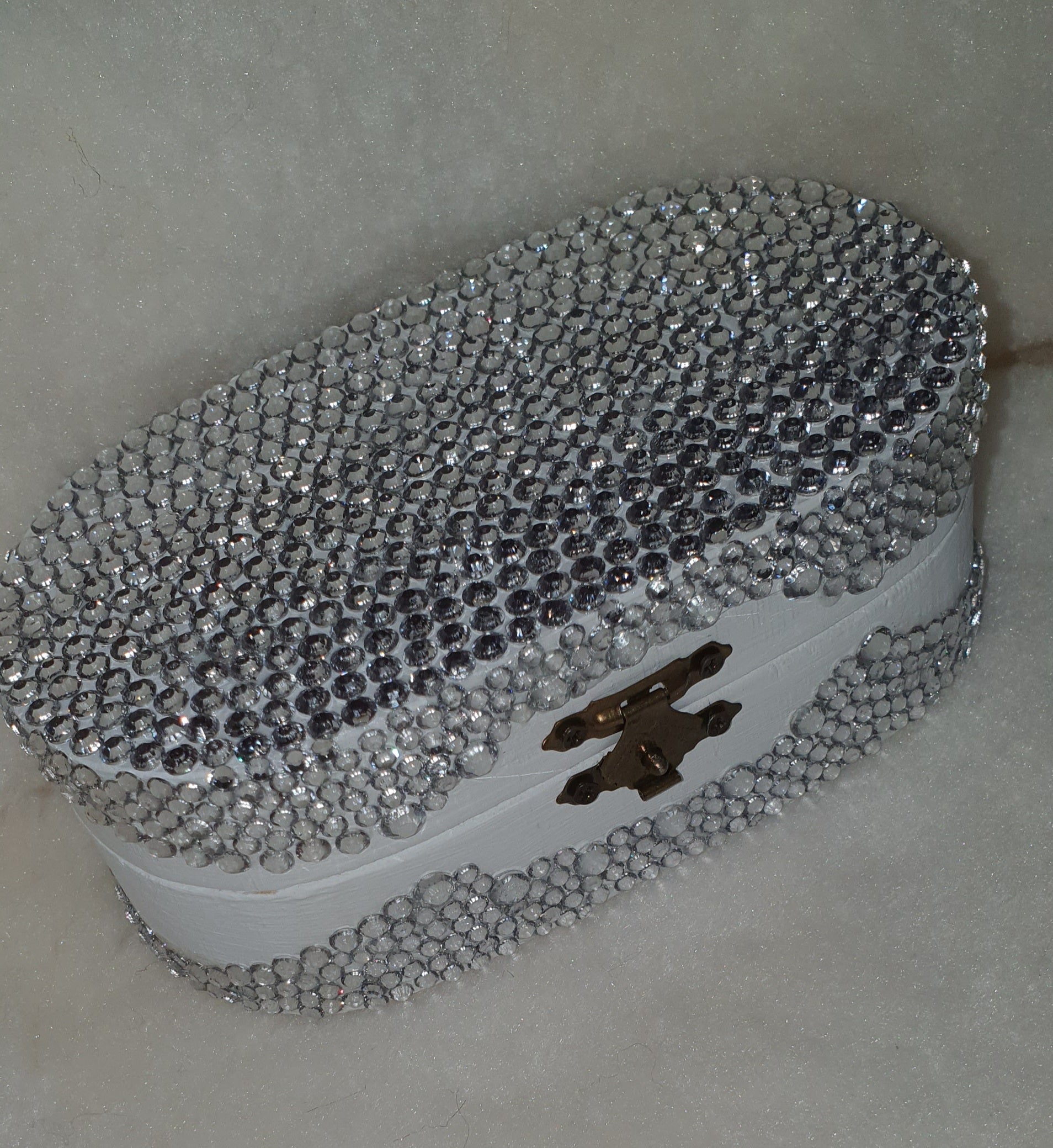 Elegant clutch bag with crystal embellishments on a neutral background