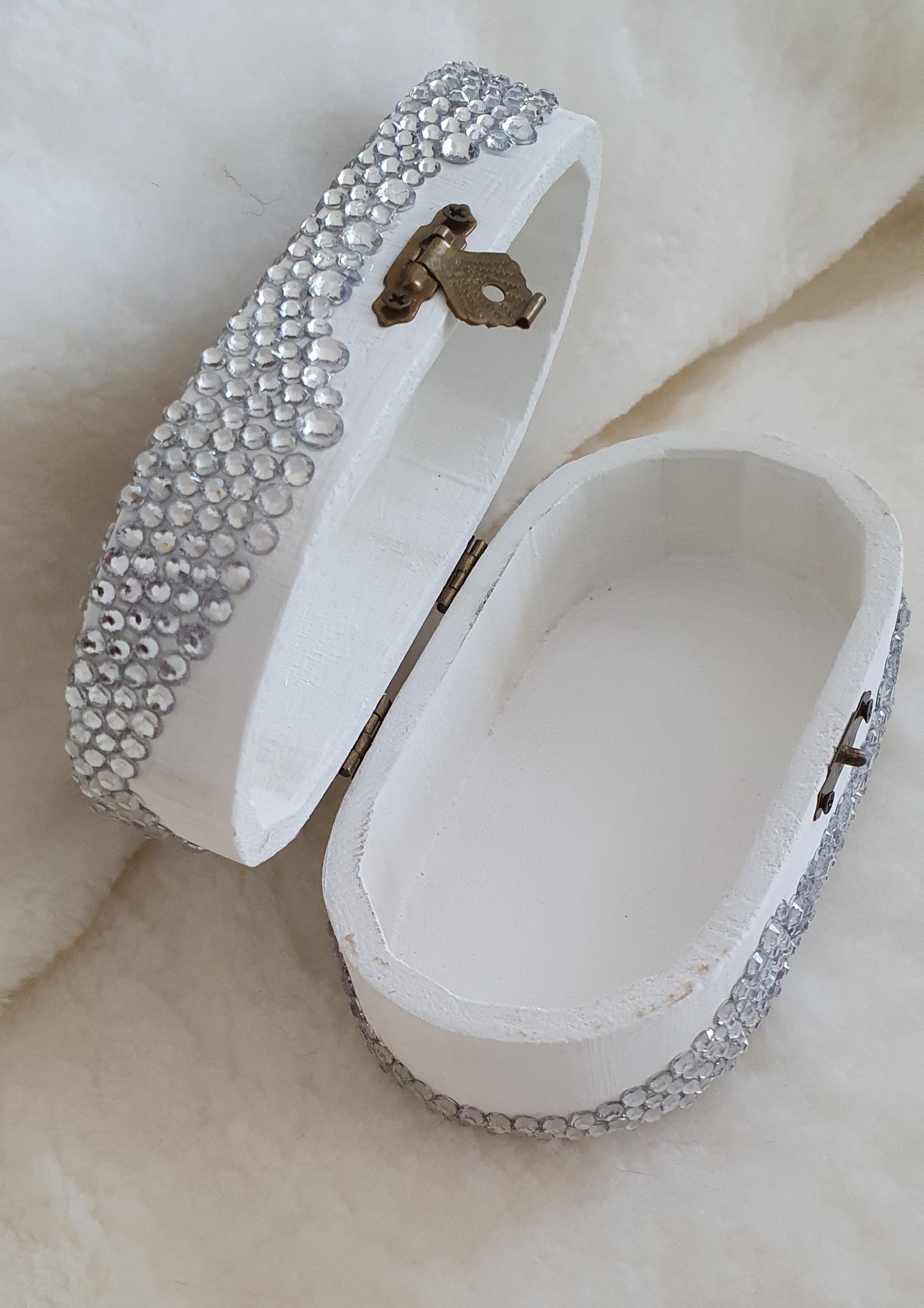 White jewelry box with silver embellishments on a light background