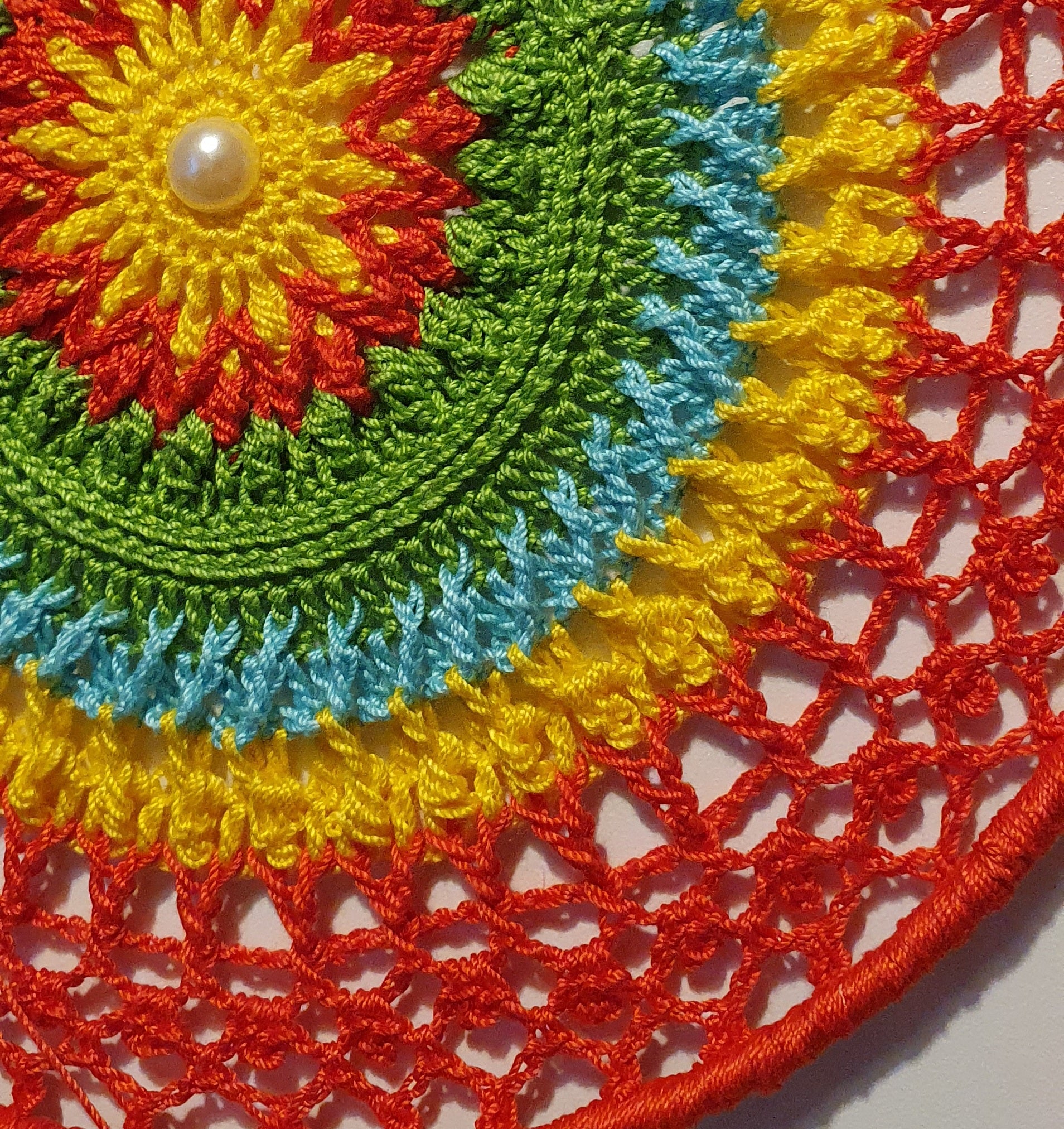 Colorful crocheted dream catcher with a pearl in the center 