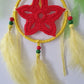 Decorative dreamcatcher with red center, yellow rim, and feathers 
