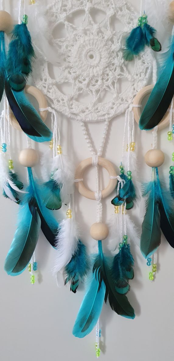 white dreamcatcher with white and turquoise feathers