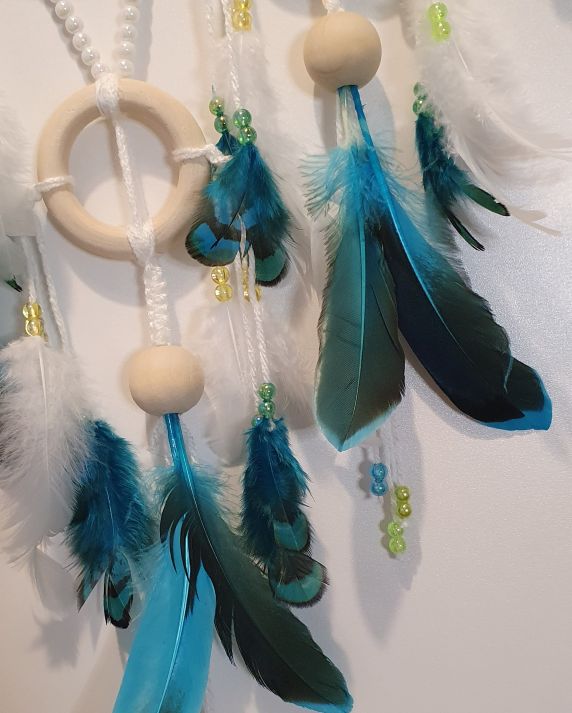 white and turquoise feathers on dreamcatcher